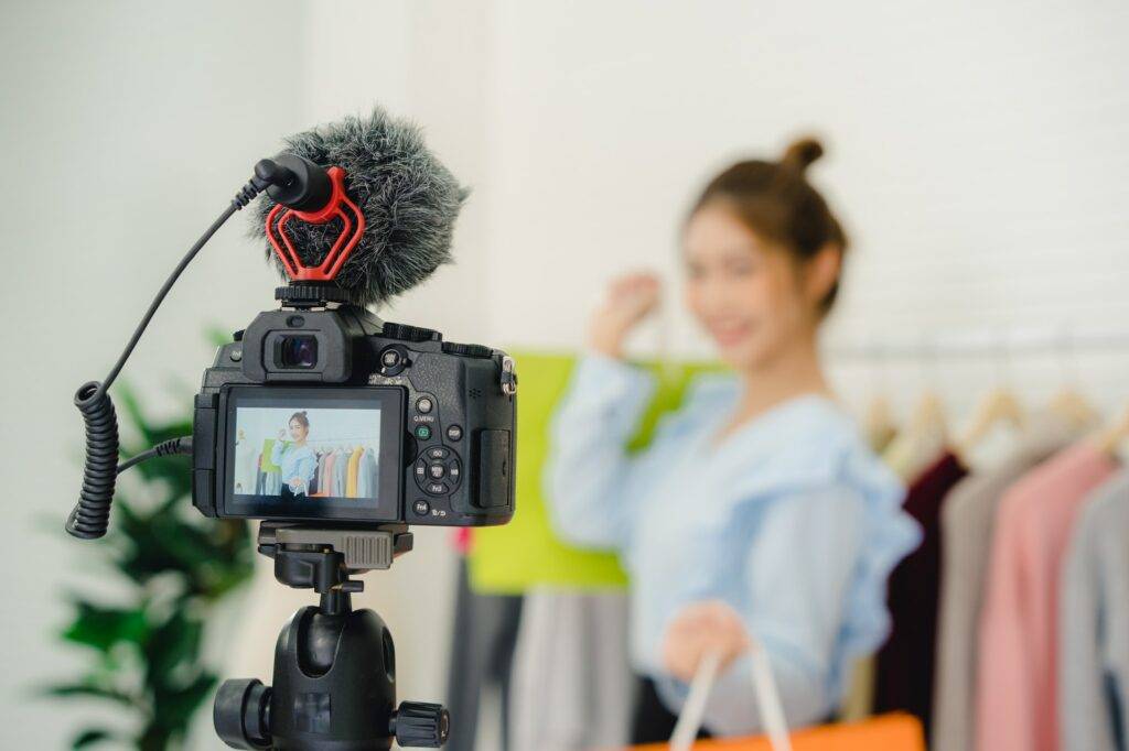 Asian fashion female blogger online influencer holding shopping bags.